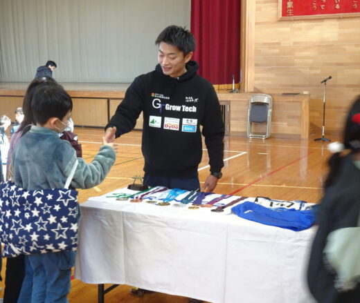 児童に声をかけながら握手する亀山さんの写真